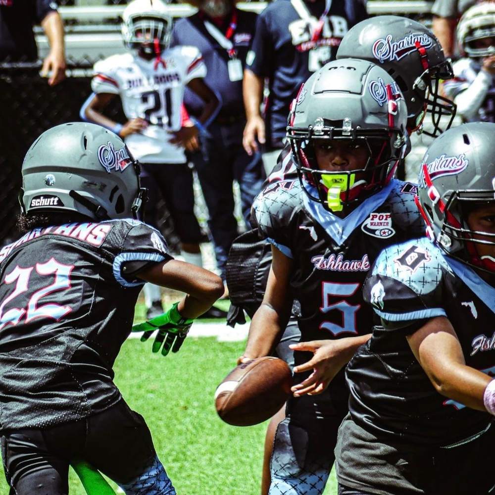 Spartans players in black jerseys celebrating on the field