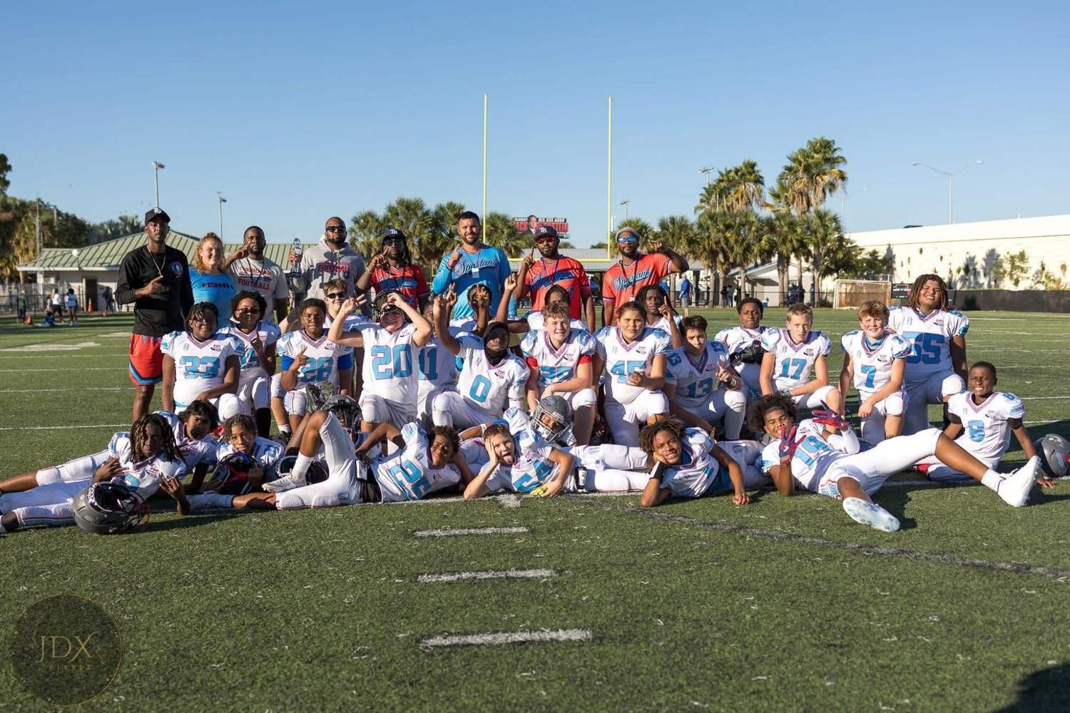 FishHawk Spartans team and coaches posing on the field in white jerseys