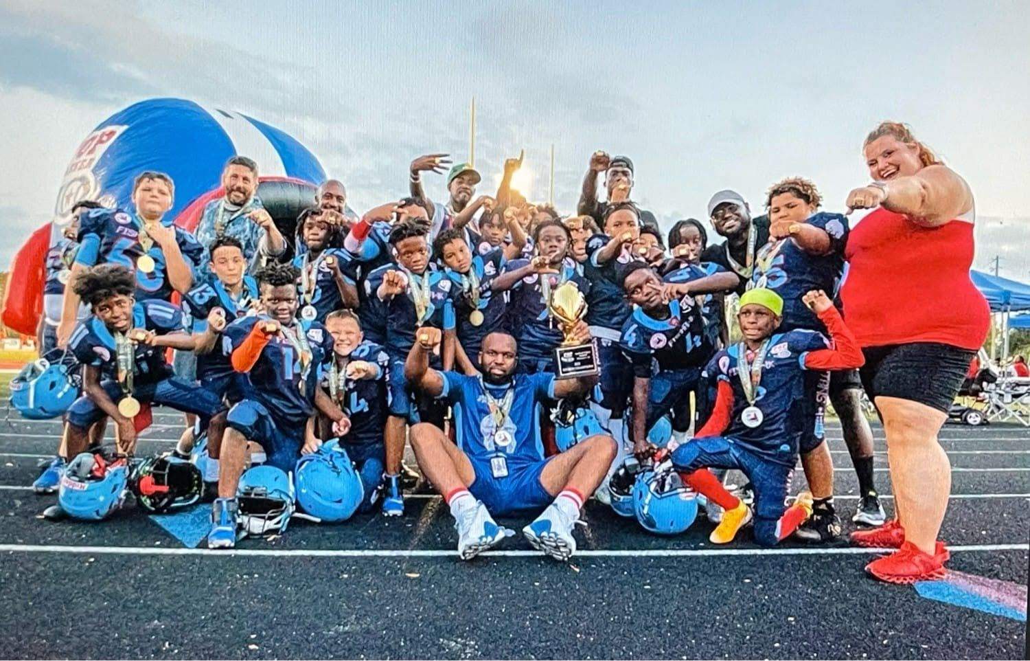 Spartans team celebrating with medals and a championship trophy