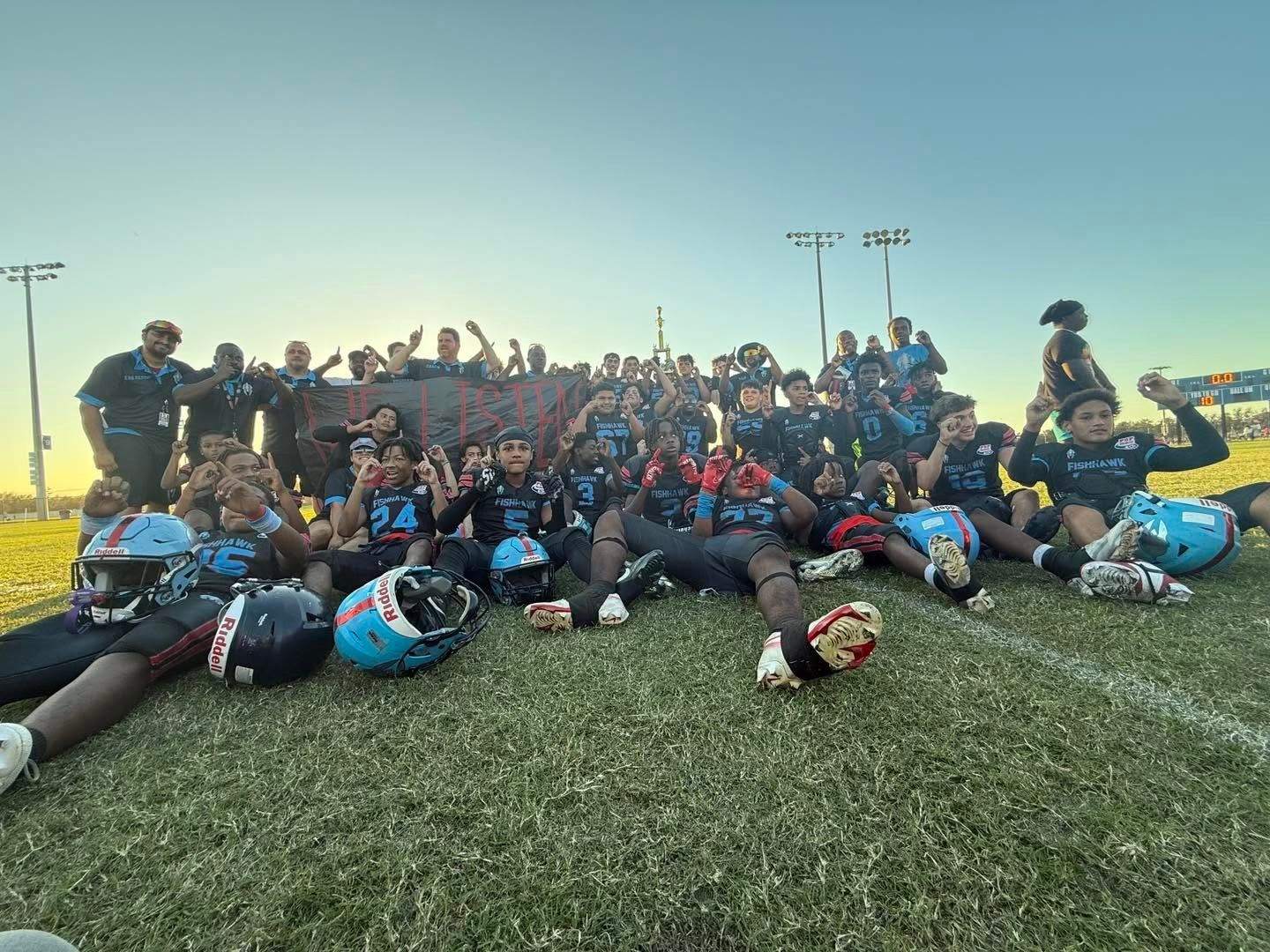 Spartans players and coaches at sunset after a game